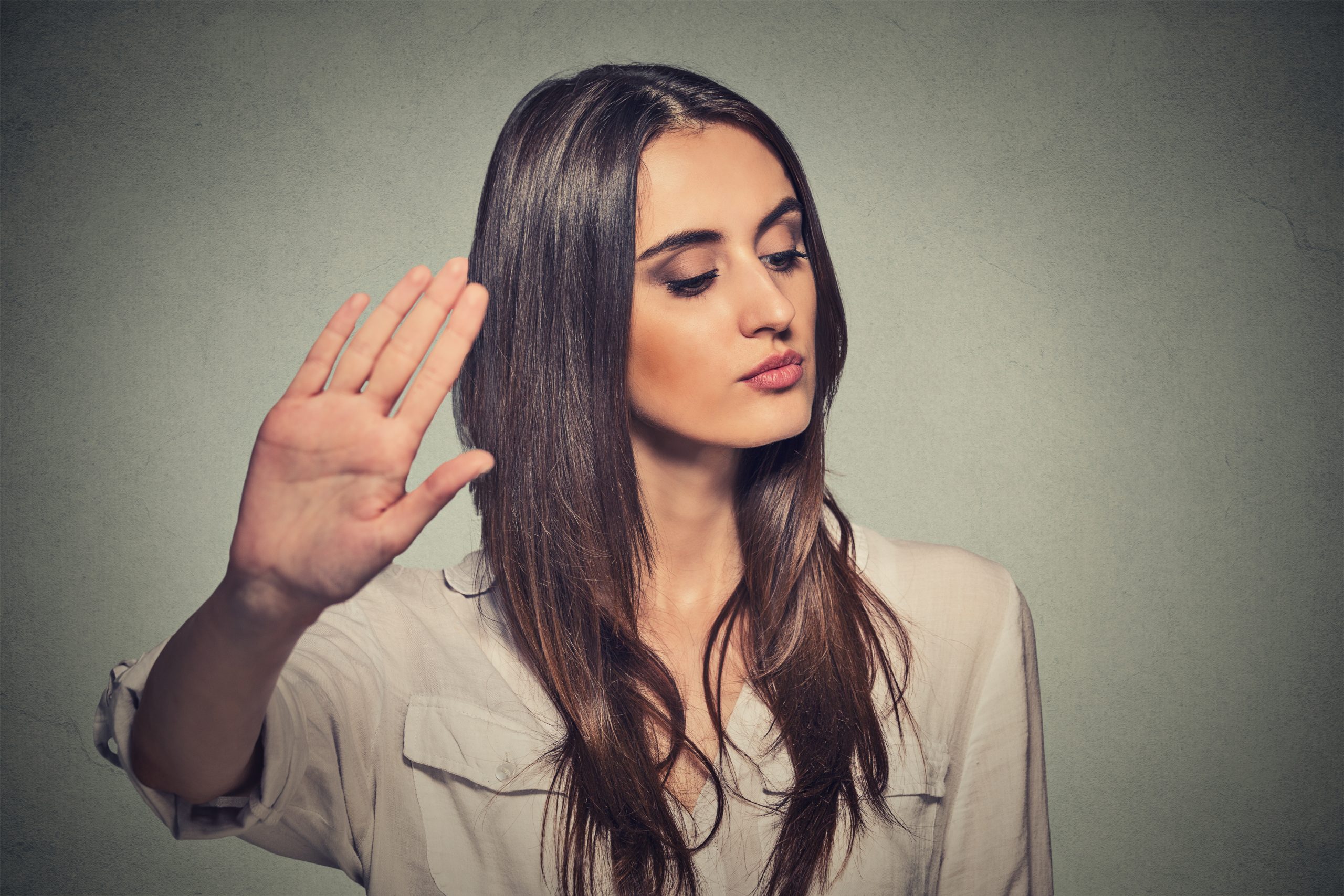 annoyed angry woman with bad attitude giving talk to hand gesture